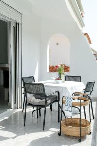 a dining room with a white table and chairs at Villa Oneiron in Anavyssos