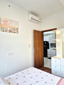 a bedroom with a bed and a kitchen at Swanbay - Rice's House in Nhơn Trạch