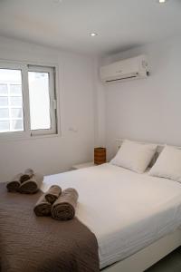 a bedroom with a large white bed with towels on it at Villa Oneiron in Anavyssos +90 photos