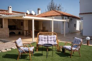 a group of chairs and a table in a yard at Villa Oneiron in Anavyssos