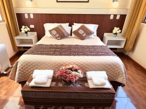 a bedroom with a large bed with flowers on it at Boutique Inka Hotel in Ollantaytambo