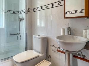 a bathroom with a toilet and a sink and a shower at Cozy & Calm Beach House in Ovar
