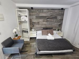 a bedroom with a large bed and a chair at Alojamientos Santa Pola in Santa Pola