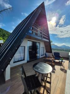 a house with a balcony with a table and chairs at Mirante Vista Nobre in Maricá