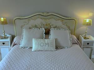 a bed with white pillows with the words love at Chambres et Gîte PEYROUTAS " CAMILLE" Vignonet St Emilion in Vignonet