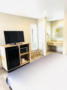 a bedroom with a bed and a flat screen tv at Super 8 by Wyndham Corpus Christi in Corpus Christi