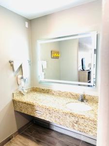 a bathroom with a sink and a large mirror at Super 8 by Wyndham Corpus Christi in Corpus Christi +8 photos