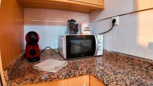 a kitchen counter with a microwave on a counter top at Apartalux San Pedro Playa in San Pedro del Pinatar