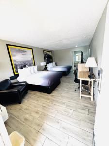 a hotel room with two beds and a desk at Super 8 by Wyndham Corpus Christi in Corpus Christi