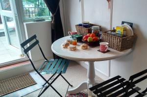 a table with a bowl of fruit and baskets on it at Crystal Palace B&B in London
