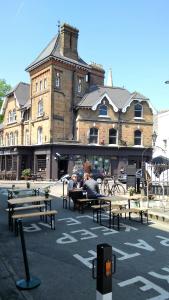 a group of people sitting at tables in front of a building at Crystal Palace B&B in Crystal Palace