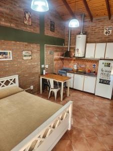 a room with two beds and a table and a kitchen at Los Lúpulos Departamentos Privados in El Bolsón