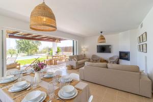 a living room with a dining table and a couch at Villa Conguitosby 3VILLAS in Sant Lluis