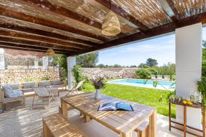 a patio with a table and chairs and a swimming pool at Villa Conguitosby 3VILLAS in Sant Lluis