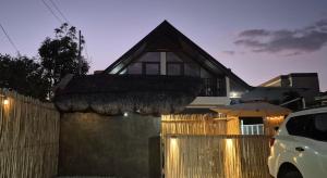 a house with a fence in front of it at Casa Elia San Juan La Union Beach Cabin in San Juan