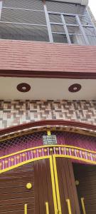 a building with a brown door with a red roof at Shree Rameshth Homestay in Ayodhya