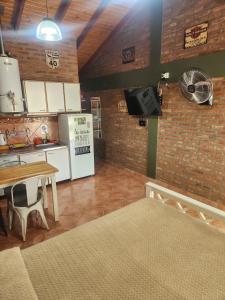 a kitchen with a table and a refrigerator at Los Lúpulos Departamentos Privados in El Bolsón