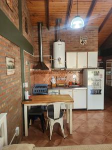a kitchen with a wooden table and a refrigerator at Los Lúpulos Departamentos Privados in El Bolsón