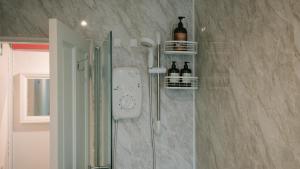a bathroom with a shower with wine bottles on the wall at Central Dundee, 1 Bed, Parking, 3 Nights in Dundee