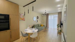 a kitchen and living room with a table and a couch at Parkside Dighomi in Tbilisi City