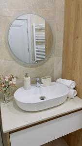 a bathroom with a white sink and a mirror at Parkside Dighomi in Tbilisi City +44 photos