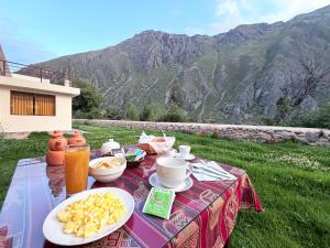 a table with food on it with a view of a mountain at Boutique Inka Hotel in Ollantaytambo +19 photos