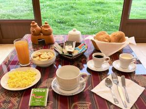 a table topped with cups and plates of food at Boutique Inka Hotel in Ollantaytambo