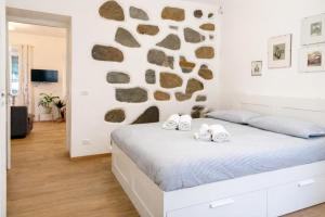 a bedroom with a bed and a stone wall at Trilocale spazioso a 6 minuti dal centro in Trieste