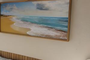 a painting of the ocean on a wall at Lotf Privativo in Volta Redonda