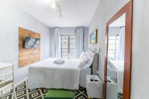 a bedroom with a large white bed and a mirror at Lotf Privativo in Volta Redonda +12 photos