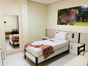 a bedroom with a bed with a picture of a bear on the wall at Gaivota Hotel in Eldorado dos Carajás