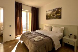 a bedroom with a bed and a large window at Hotel Brilant in Shëngjin