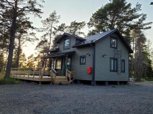 a tiny house with a porch and a deck at Villa Furuviken in Kristinestad