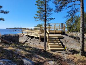 a wooden deck with stairs next to a body of water at Villa Furuviken in Kristinestad +3 photos