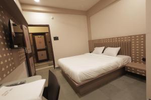 a small bedroom with a bed and a mirror at Hotel Best Inn in Valsād +2 photos