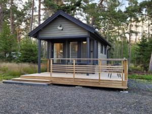 a tiny house sitting on a deck in the woods at Villa Furuviken in Kristinestad