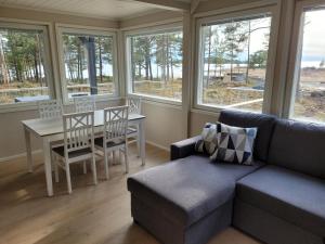 a living room with a couch and a table and chairs at Villa Furuviken in Kristinestad