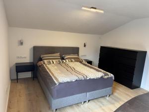 a bedroom with a bed and a black dresser at Tirol Stay in Ebbs