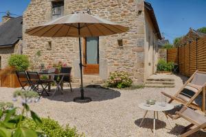 a patio with an umbrella and a table and chairs at La Maison d'Adèle in Baden