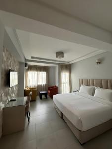a hotel room with a bed and a couch at Appart Hotel Bloom in Al Hoceïma