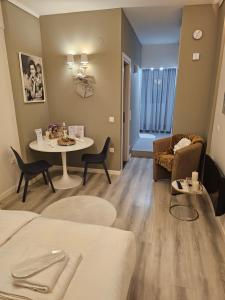 a room with a bed and a table and a couch at TRISAP Luxury Suites T Suite in Thessaloniki