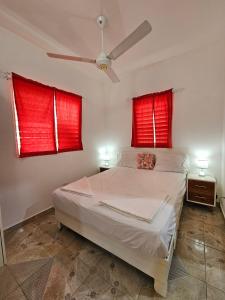 a bedroom with red windows and a white bed at Caribbean Domicil Apartment 02 in Las Terrenas