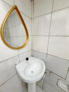 a bathroom with a white sink and a mirror at Quarto no centro 207 in Manaus