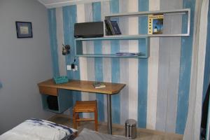 ein Schlafzimmer mit einem Schreibtisch und einem Bett sowie einem Schreibtisch mit einem Stuhl in der Unterkunft Un petit coin de paradis in Barbâtre