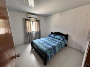 a bedroom with a bed with blue pillows on it at Casa Cabaña Elena - Coveñas in San Antero
