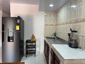 a kitchen with a refrigerator and a counter top at Casa Cabaña Elena - Coveñas in San Antero +9 photos
