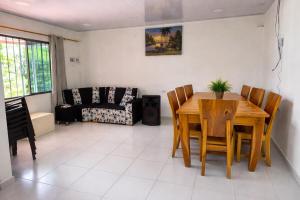a dining room with a table and chairs and a couch at Casa Cabaña Elena - Coveñas in San Antero