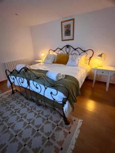 a bedroom with a large bed with a wrought iron frame at The Cabin at Swelle Cottages in Poundstock