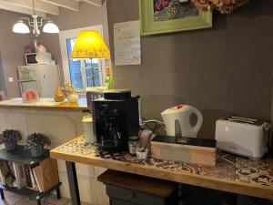 a kitchen counter with a coffee maker on a table at Chambres et Gîte PEYROUTAS " CAMILLE" Vignonet St Emilion in Vignonet