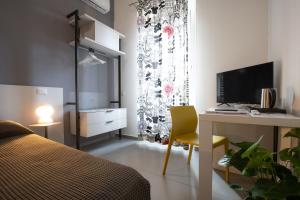 a bedroom with a bed and a desk with a computer at Suite Inn Catania in Catania